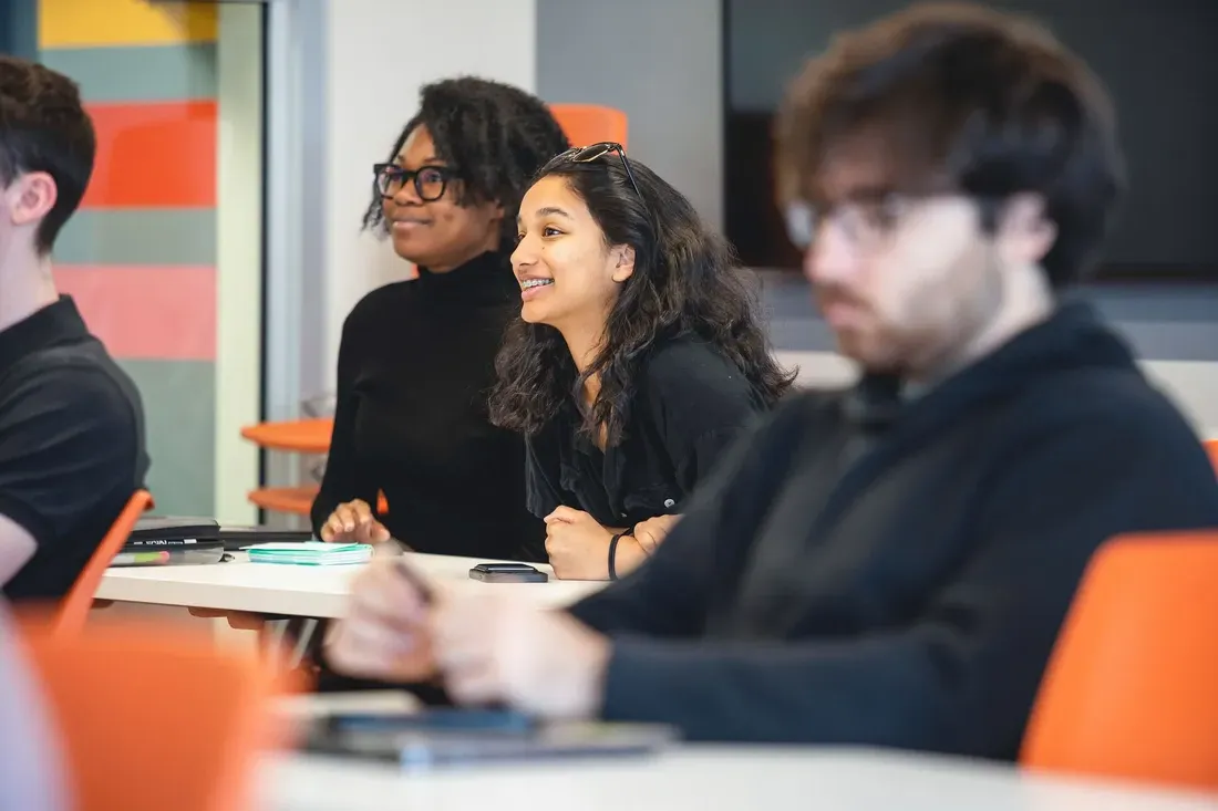 Students smiling and learning in class.